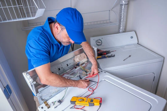 Technician using a diagnostic meter on a top-loading washing machine